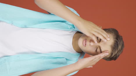 Vertical-video-of-Boy-with-migraine-is-experiencing-pain.